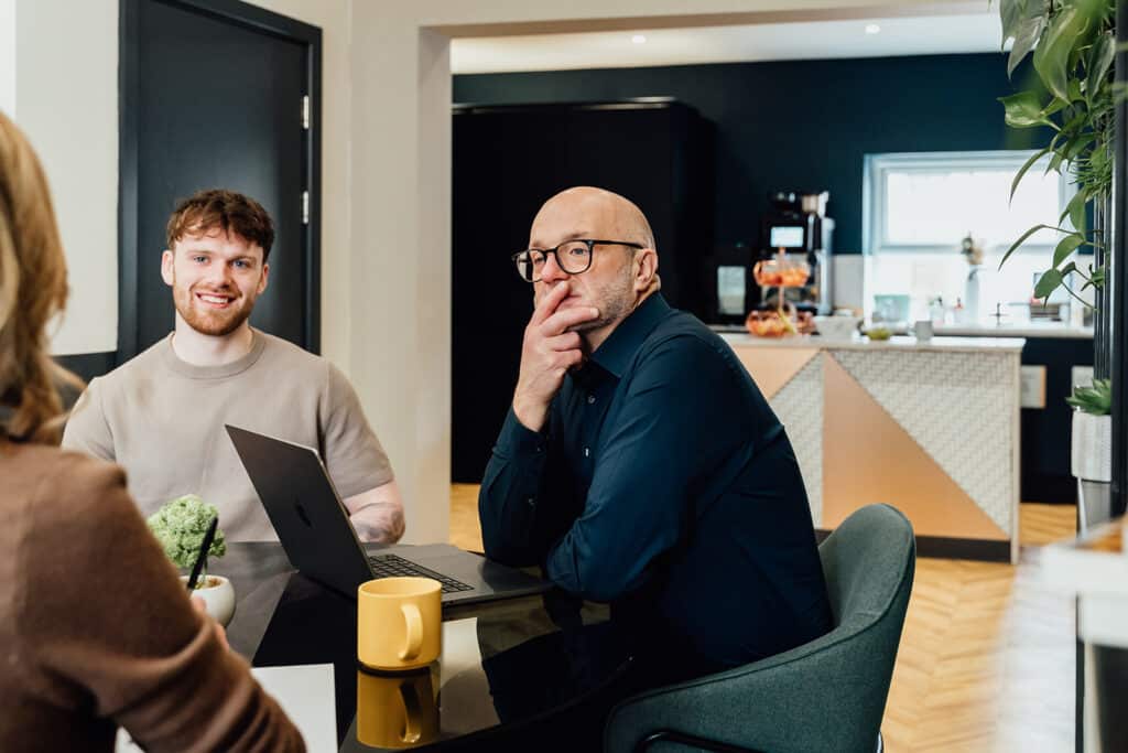 Independent chair leading a strategic board meeting with marketing agency founders in a modern office.