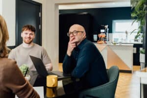 Independent chair leading a strategic board meeting with marketing agency founders in a modern office.