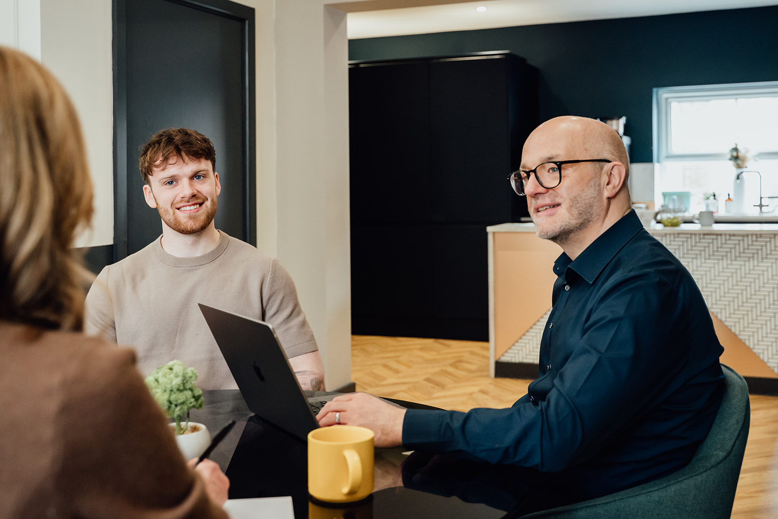 Gareth and Callum Healey with a client in a meeting room.